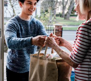 Volunteer drops off groceries to client