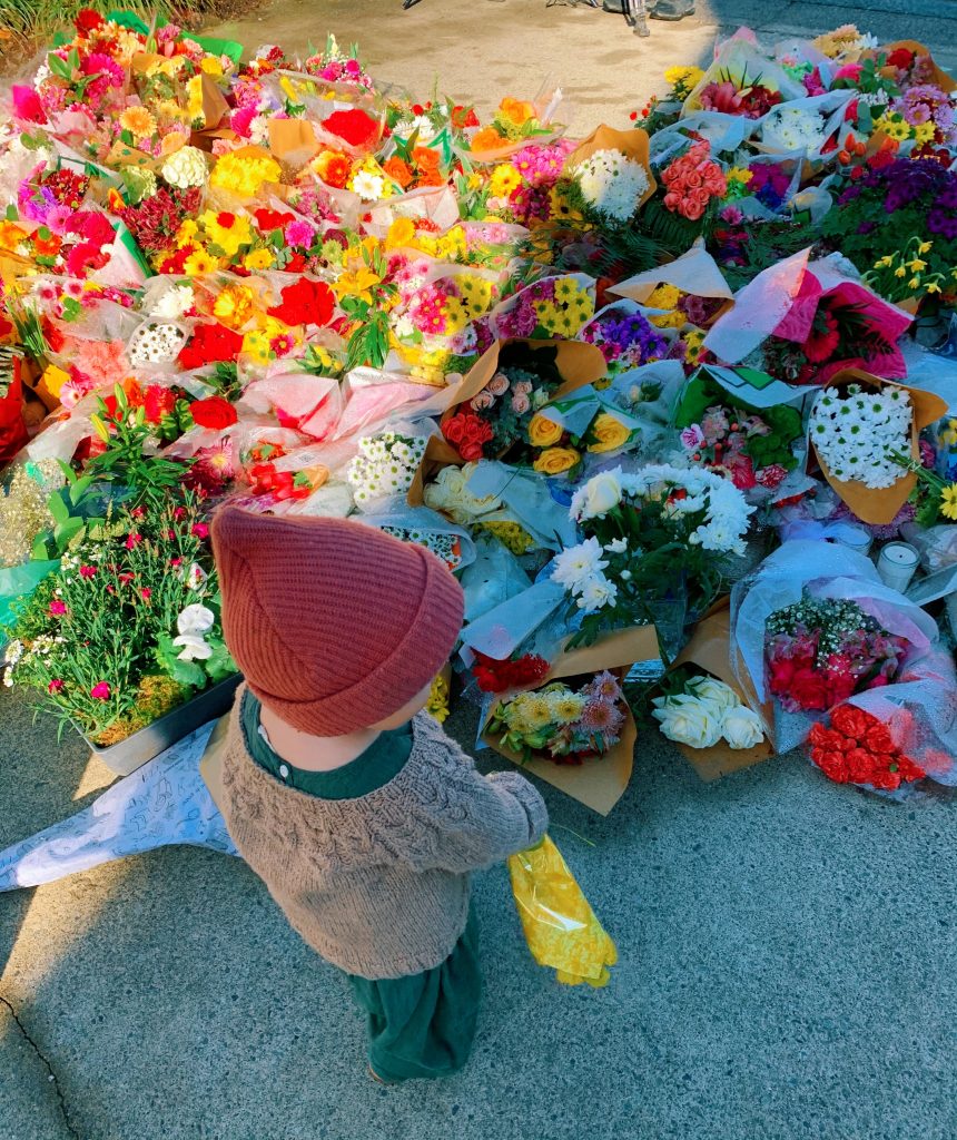 young girl placing flowers at the memorial at lynn valley public library